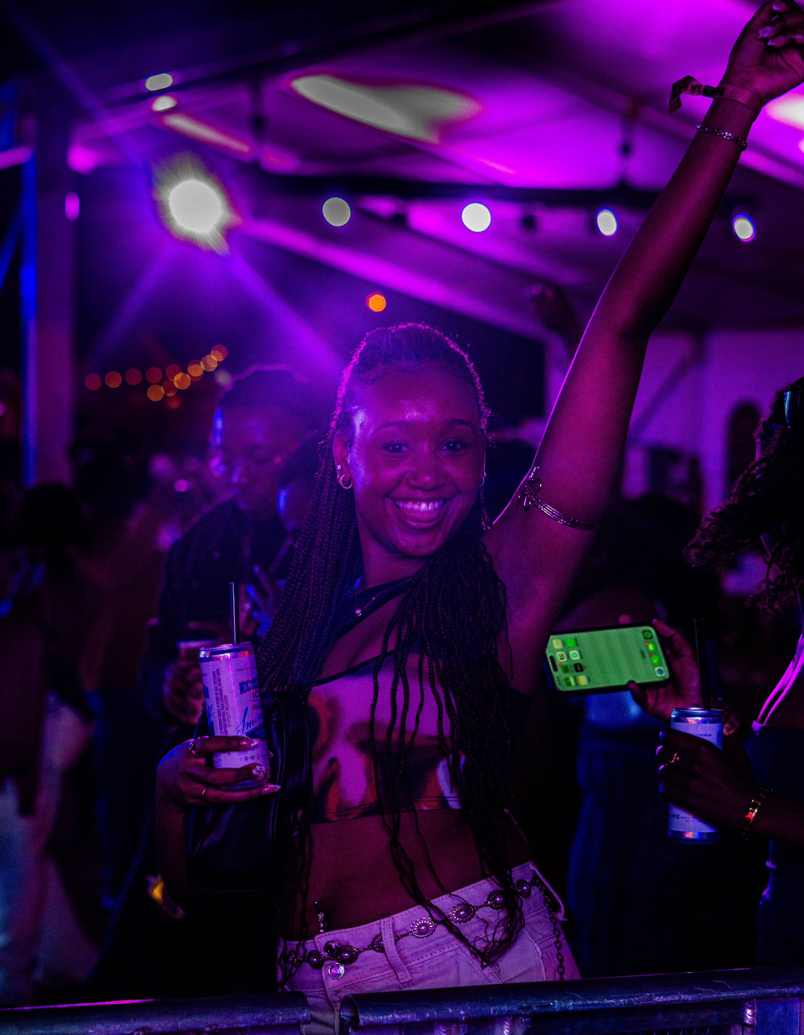 Guest smiling and dancing under purple lights at ASILI