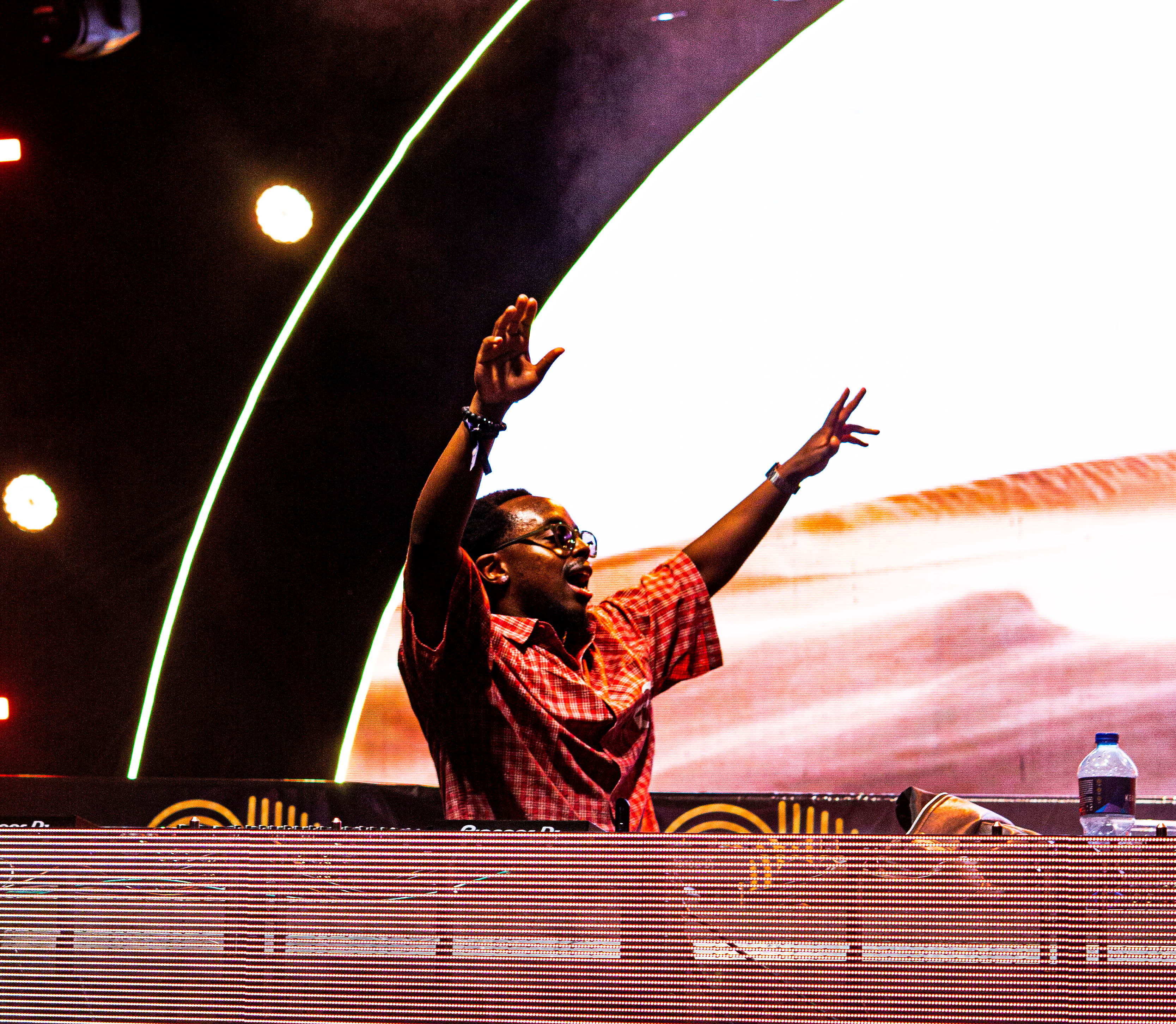 DJ celebrating with both hands raised on the ASILI stage