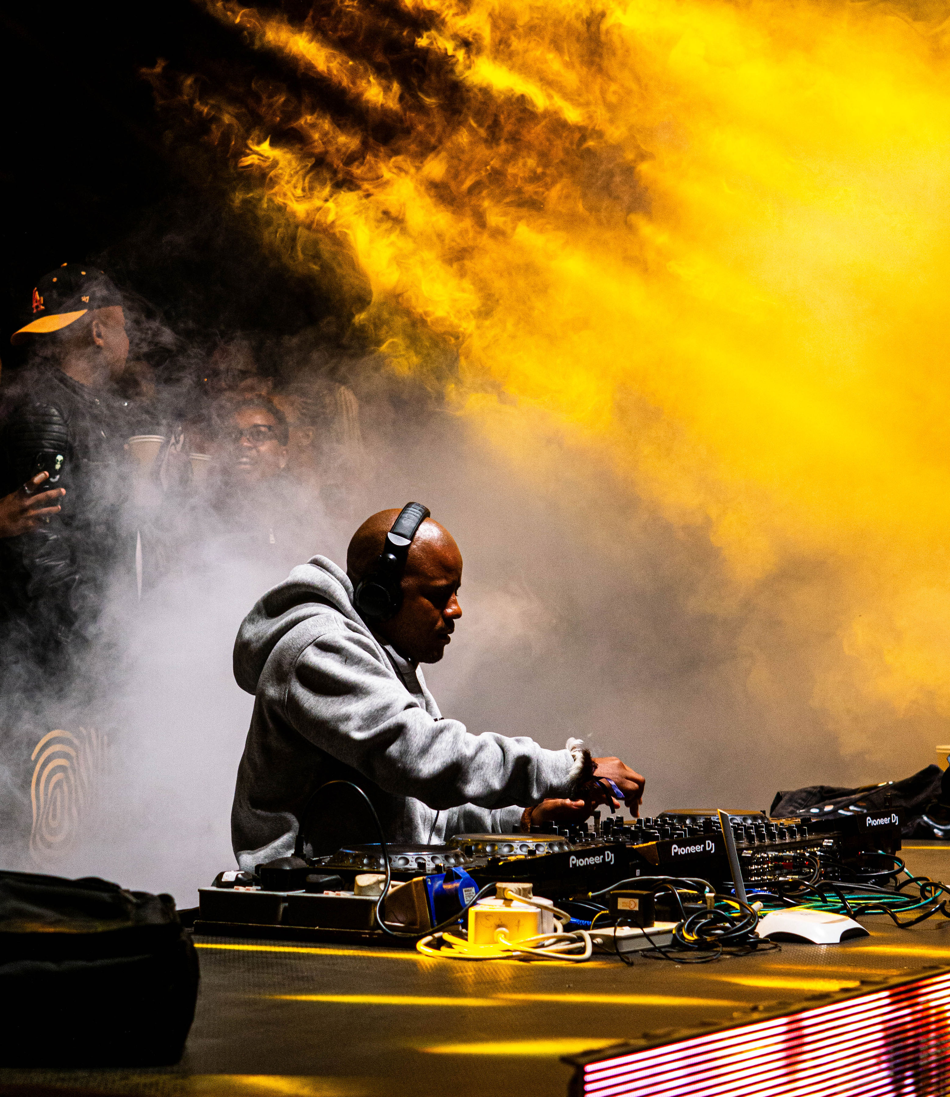 DJ performing through dramatic yellow stage smoke