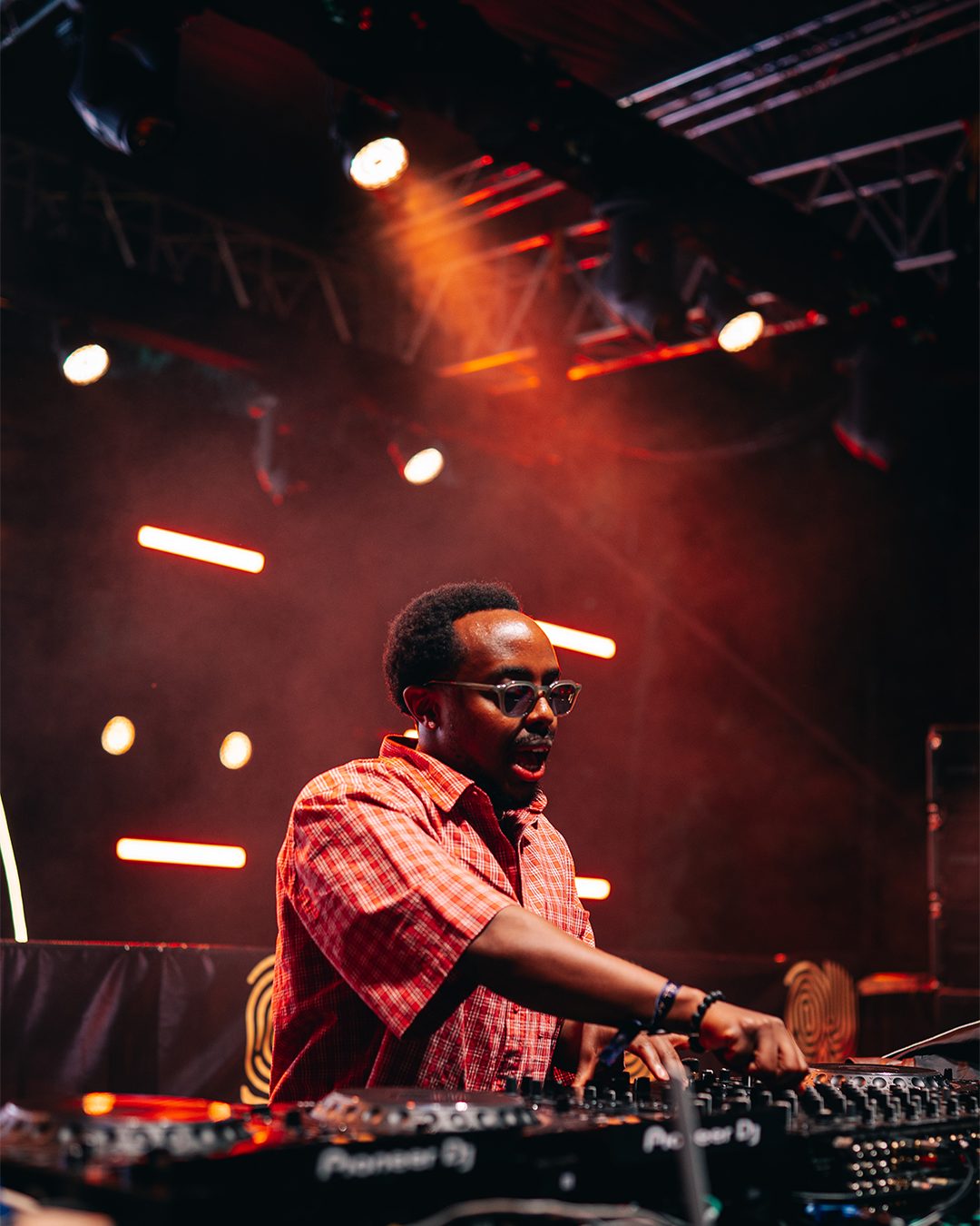 ASILI Experience DJ playing under blue smoke and stage lights
