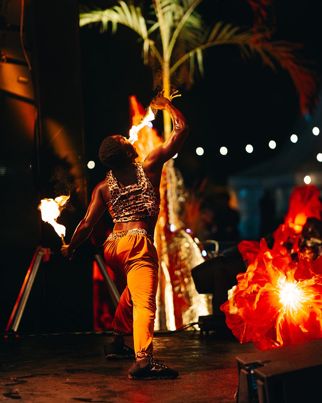 ASILI Experience fire performer on stage at night